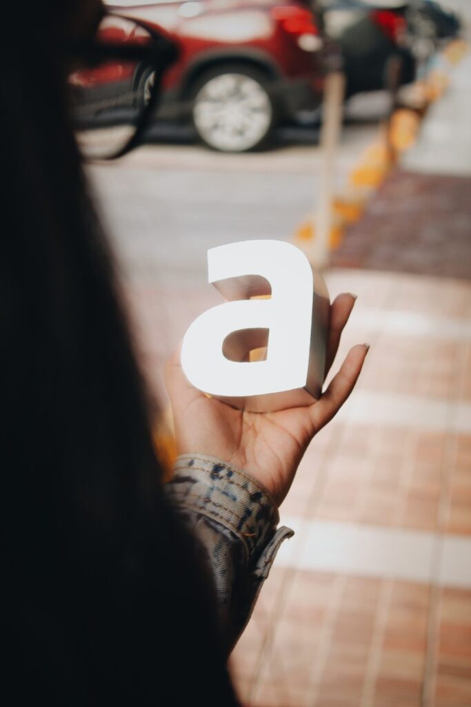 Letra a impresa con manufactura aditiva pieza sobre la mano de una chica