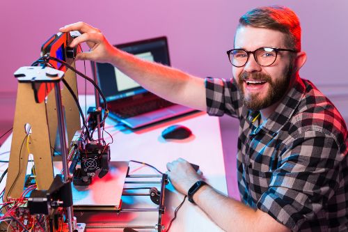 Joven posando ante la cámara mientras usa una impresión 3D